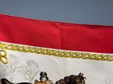 une image représentant un cheval et son cavalier sur une bannière rouge et blanche