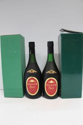deux bouteilles d'alcool posées à côté d'une boîte verte sur une surface blanche