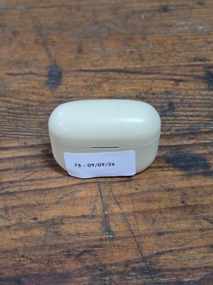 a small white box on a wooden table with a tag on it