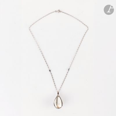 un gros plan sur un collier en argent orné d'un pendentif en forme de larme
