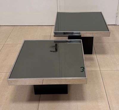 pair of chrome and glass coffee tables in the style of person