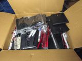 a cardboard box filled with pens and other office supplies