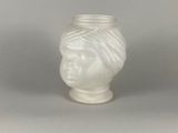 un vase blanc orné d'une tête de femme