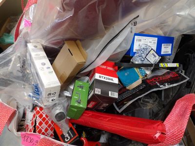 a pile of assorted electronics and other items in a box