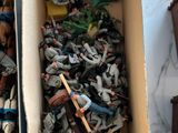 two boxes full of toy figurines sitting on a table