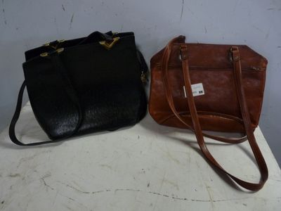 pair of black and brown handbags sitting on top of a white table