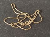 a gold chain with a skull on it on a black surface