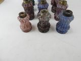 many different colored vases sitting on a white table