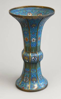 un vase bleu posé sur une table aux bordures dorées