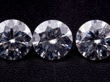 trois diamants ronds taille brillant sur fond noir