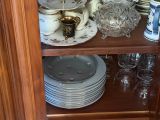 de nombreuses assiettes et tasses posées sur une étagère dans un placard