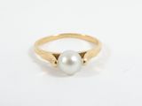 a gold ring with a white pearl in the center