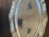 silver plate on a wooden table with a napkin and a napkin holder