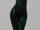 statue of a woman with a hat on her head sitting on a table
