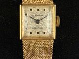 une image représentant une montre-bracelet en or avec un bracelet maillé