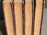 several old books stacked on top of each other on a table