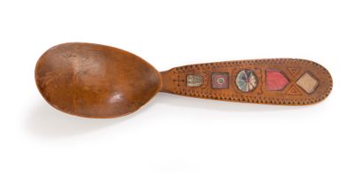 brown wooden spoon with decorative design on it on a white surface