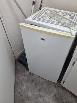 un petit réfrigérateur et un lave-vaisselle dans un coin de la pièce