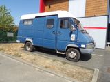une camionnette bleue garée devant un immeuble