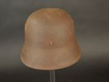 an old helmet on a stand against a gray background