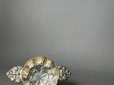 a silver plate with a turtle on it next to a coin