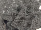 grey knitted scarf on a white surface with a small hole in the middle of the scarf
