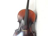 un violon accroché au mur, à côté d'un mur blanc