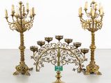 two large brass candelabs with candles on each of them