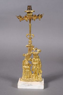 an image of a gold plated candle holder with a man and woman on it