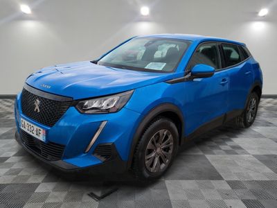 un 4x4 bleu garé sur un sol en damier dans un garage