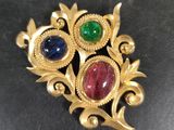 a close up of a gold broochle with gems on it
