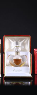 three perfume bottles in a red box on a black surface