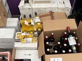 many boxes of wine sitting on the floor next to each other