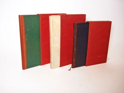 four different colored books lined up on a white surface