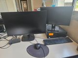 two computer monitors and a keyboard on a desk