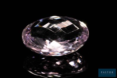 a close up of a pink diamond on a black surface