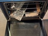 an open oven with the door open and a box in front of it