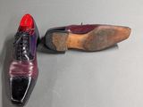 pair of purple and black shoes sitting on top of a gray surface