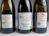 three bottles of wine are lined up on a white surface