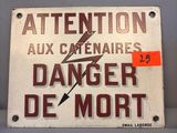 un panneau indiquant « Attention aux caténaires – danger de mort »