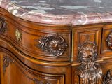 a marble top on a wooden cabinet with a lion head on the top