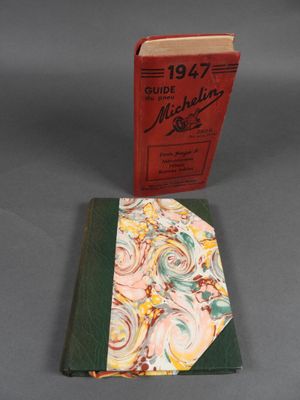 un livre rouge posé à côté d'un livre vert sur une table