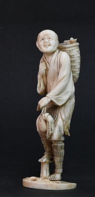 figurine en ivoire sculpté représentant un homme portant un panier sur l'épaule