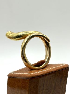 a gold ring sitting on top of a wooden block