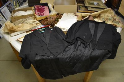 une table sur laquelle sont posés de nombreux vêtements, dans une pièce