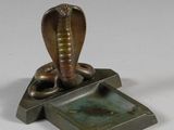 une statue représentant un cobra perché sur une boîte