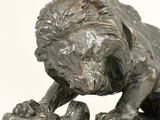 a statue of a lion that is sitting on a rock