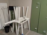 une pièce dans laquelle se trouvent plusieurs chaises blanches