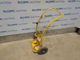 a yellow hand truck that is parked in front of a wall