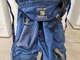un sac à dos bleu posé par terre près d'une porte